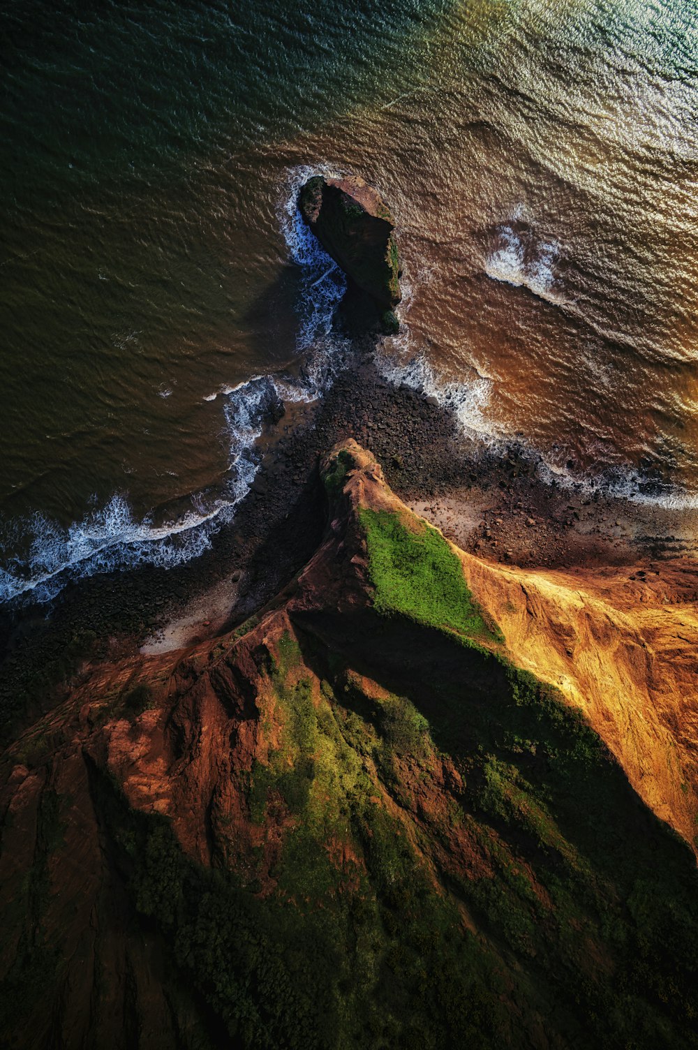 an aerial view of a beach with waves crashing on the shore