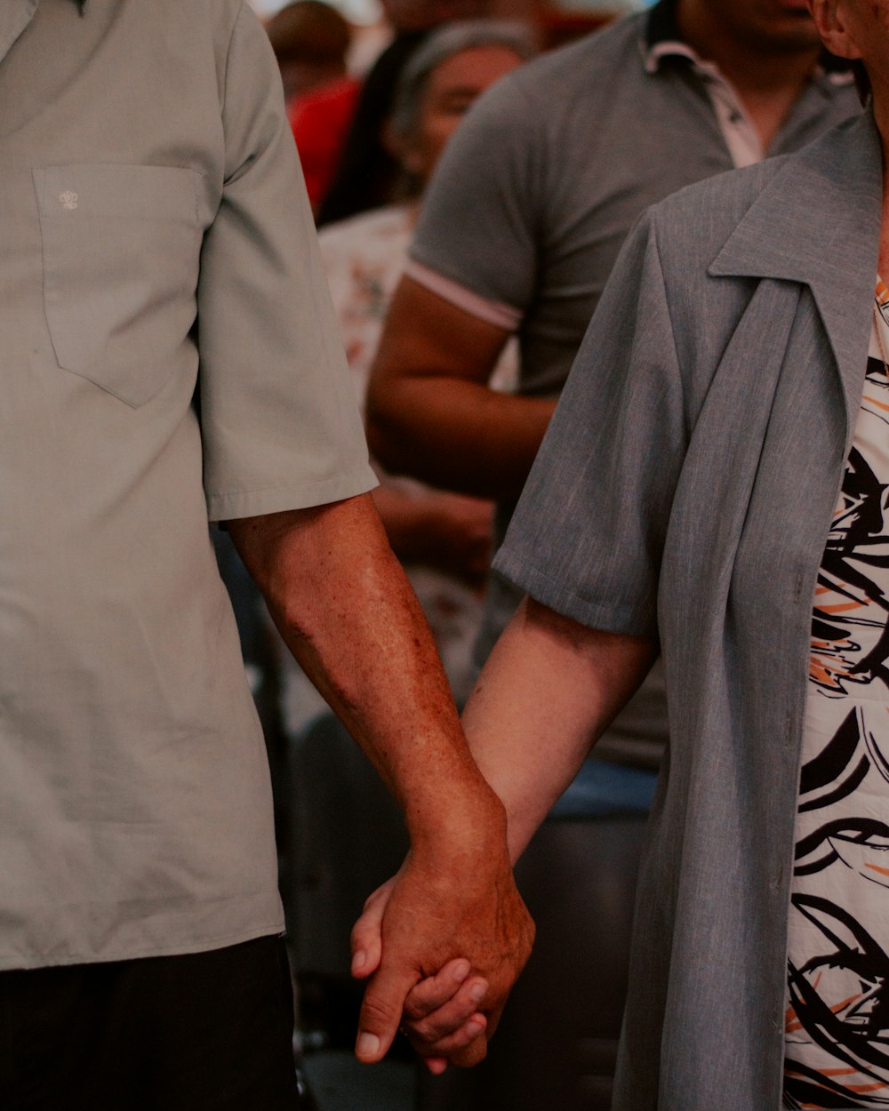 a man and a woman holding hands in front of a crowd