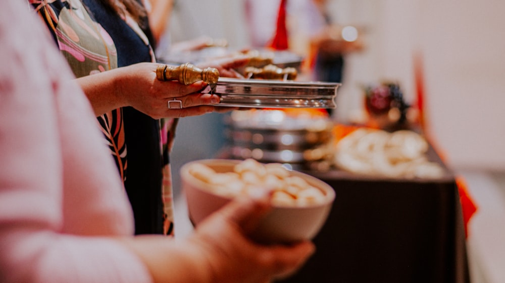 a close up of a person holding a bowl of food