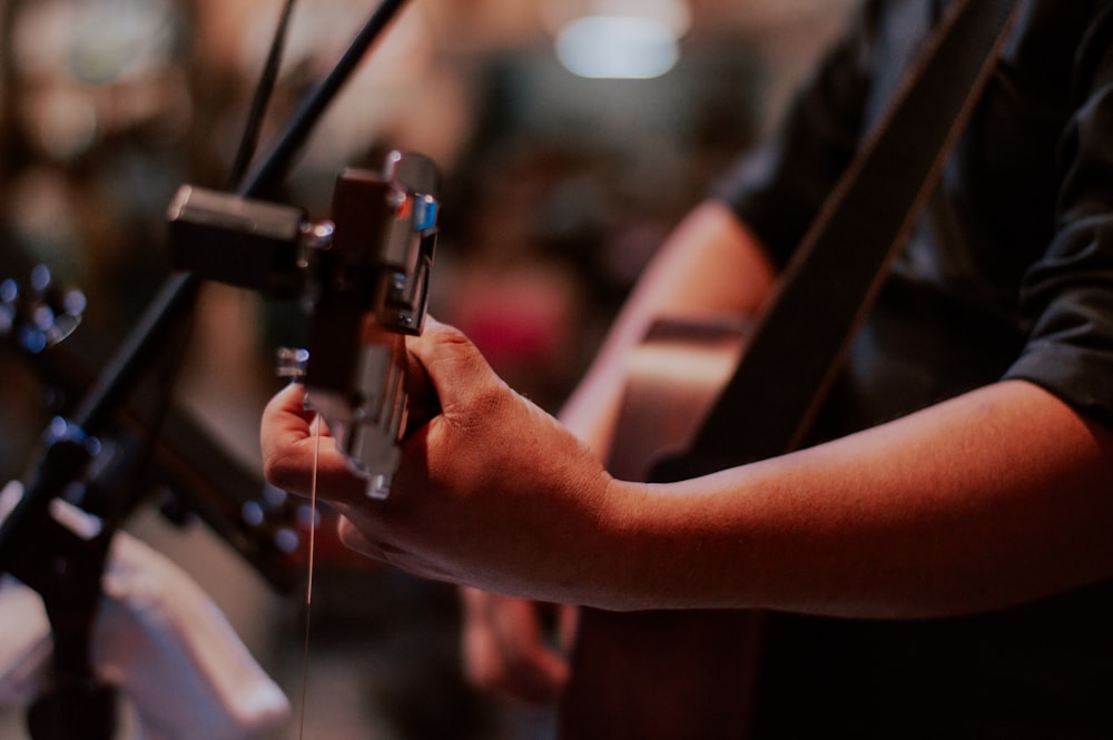 a person holding a guitar in their hand