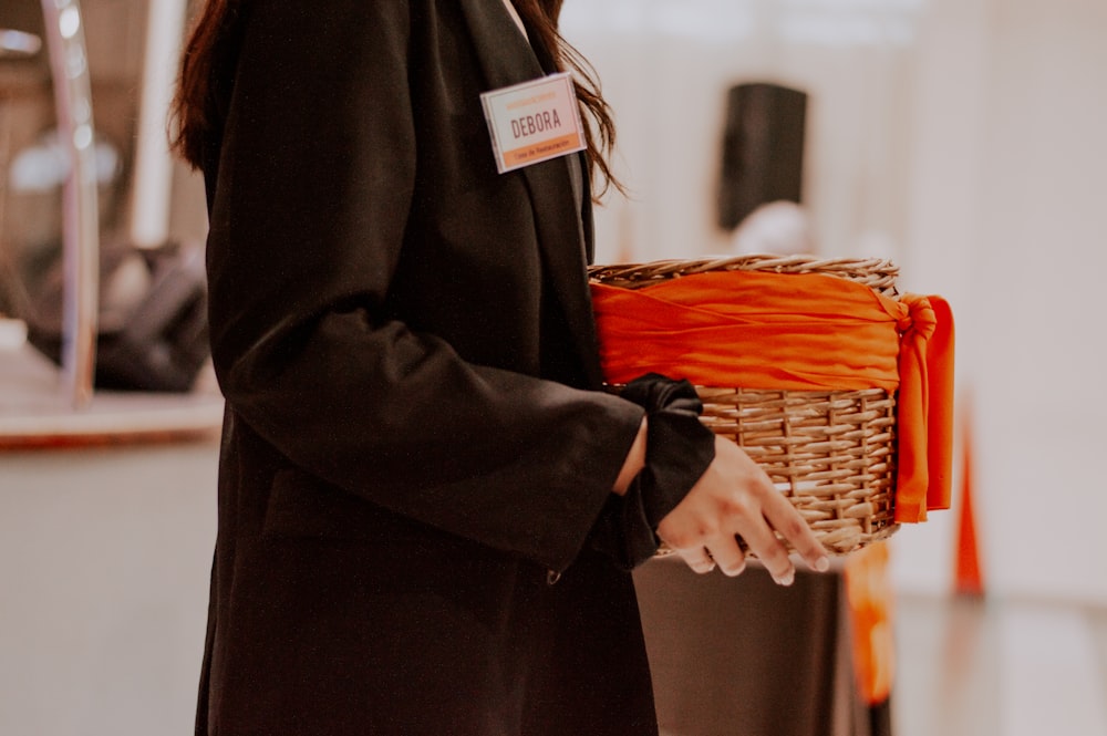 a woman holding a basket with orange ribbon