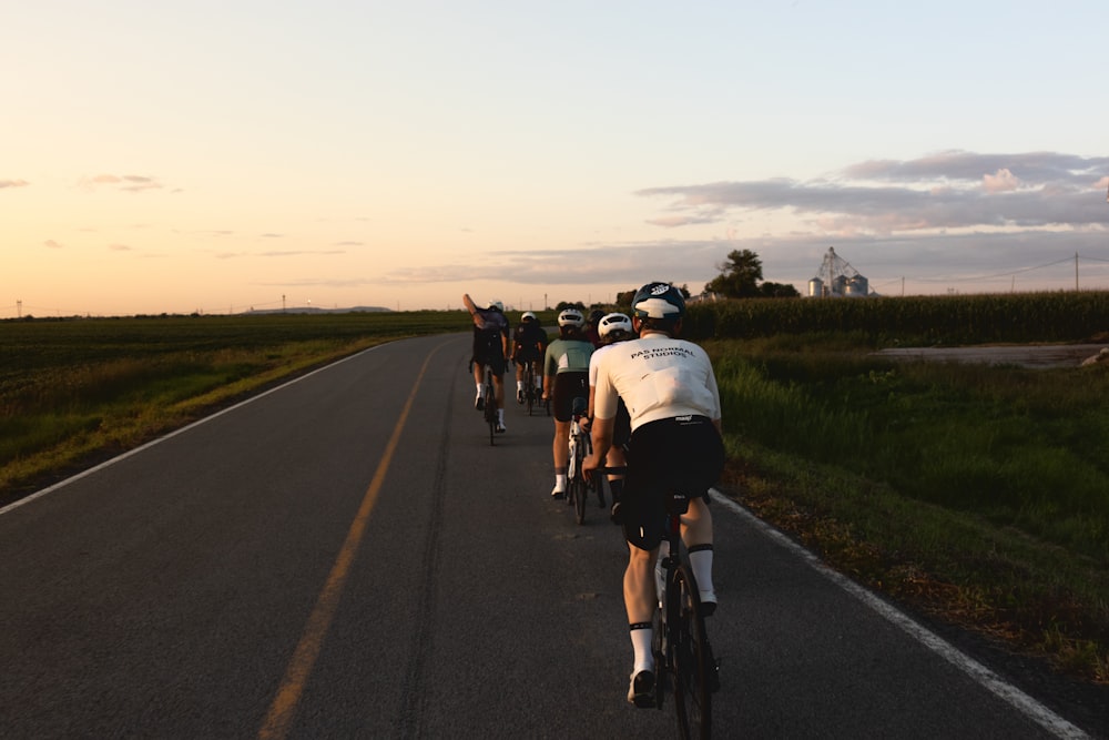 a group of people riding bikes down a road