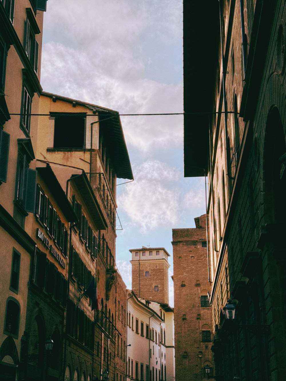 Una stradina con edifici e una torre dell'orologio sullo sfondo