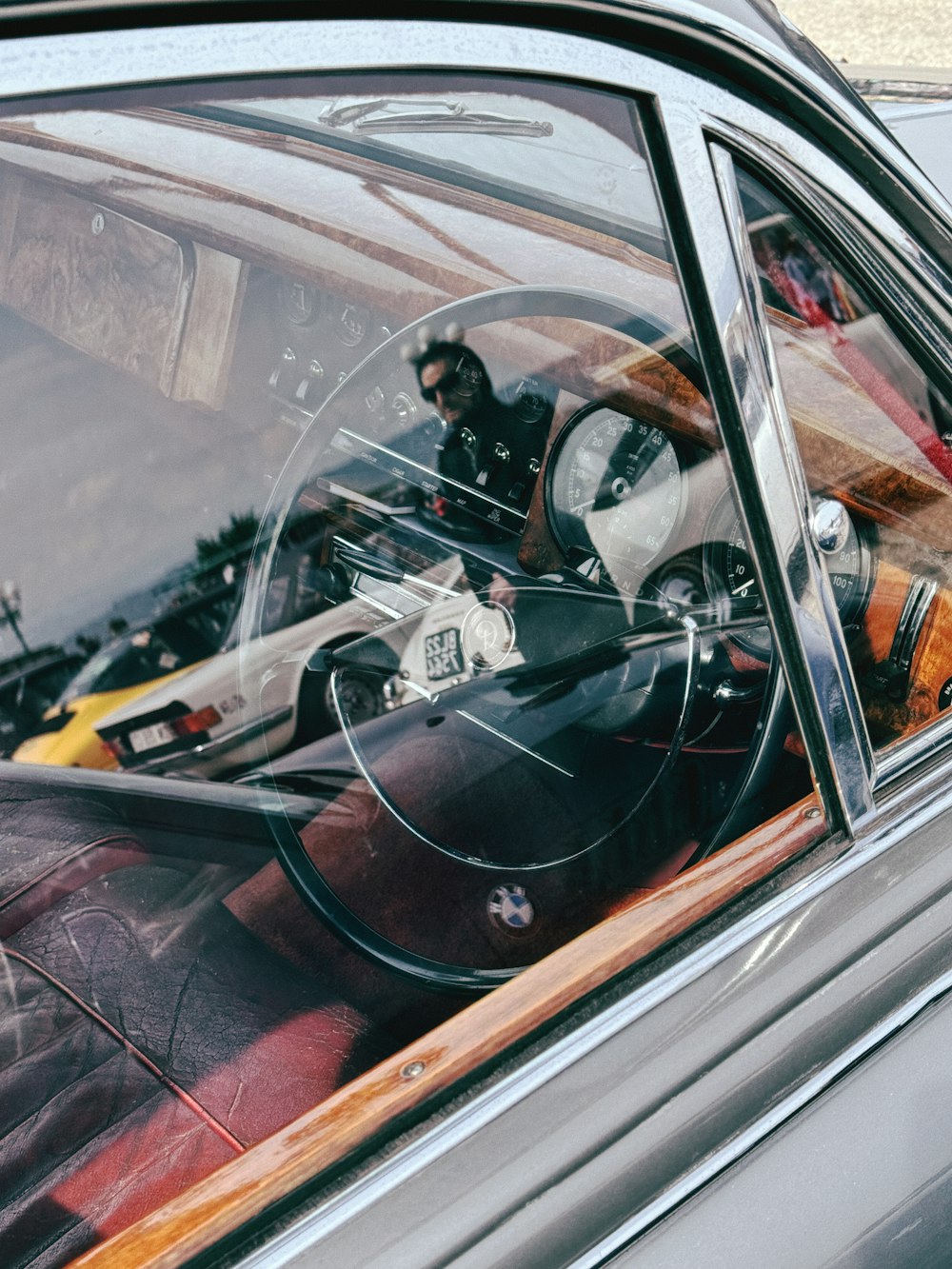 a reflection of a man sitting in a car