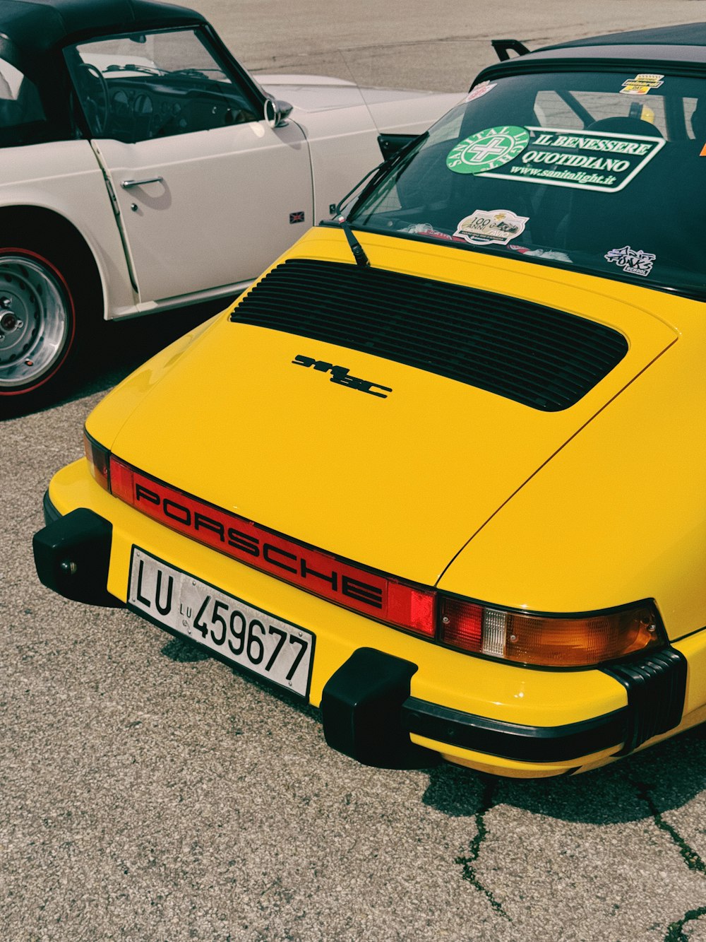 a yellow car parked next to a white car