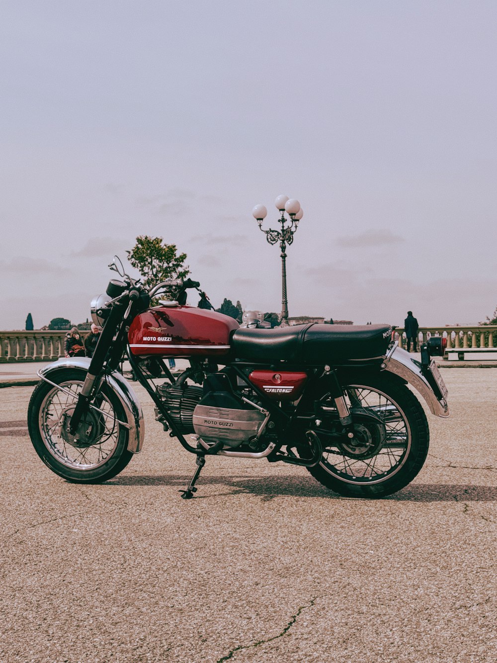 a red and black motorcycle parked in a parking lot