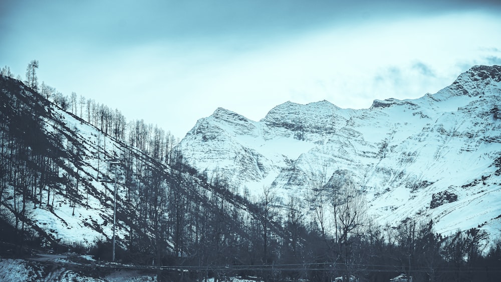 ein schneebedeckter Berg mit einer Brücke im Vordergrund