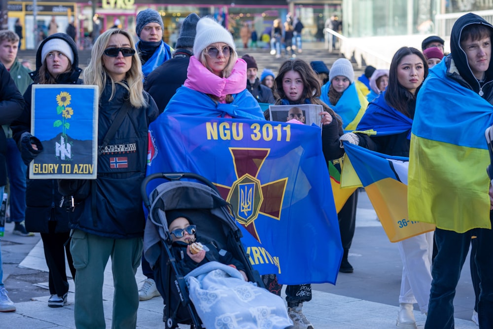 a group of people walking down a street holding flags