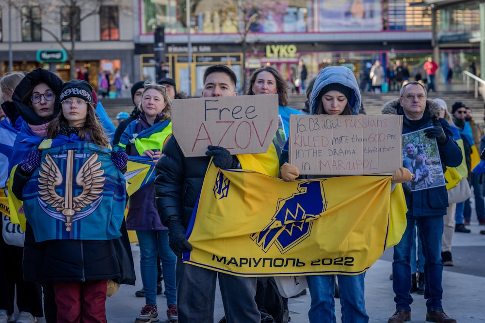 a group of people holding signs and standing on a street