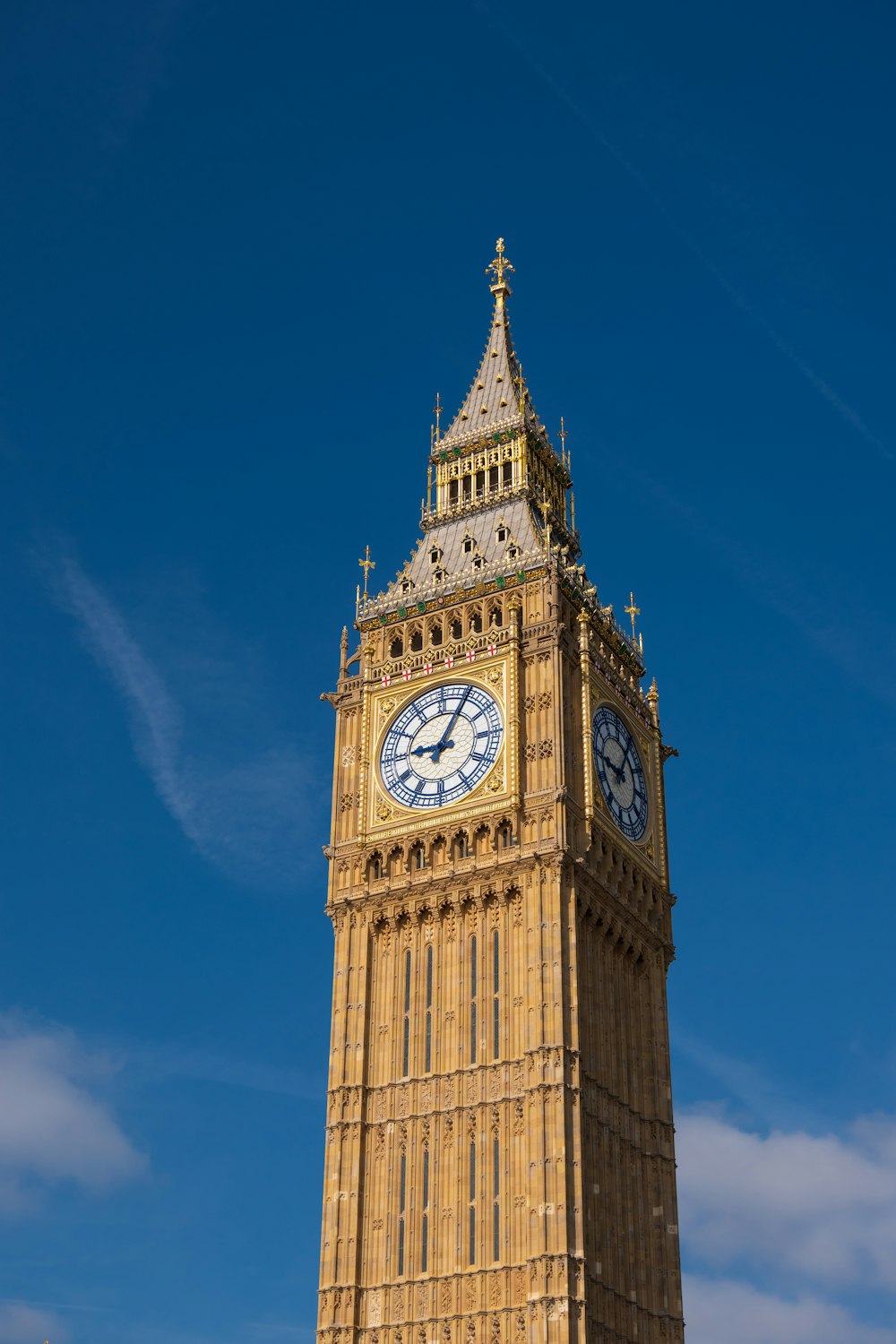 un'alta torre dell'orologio con uno sfondo di cielo