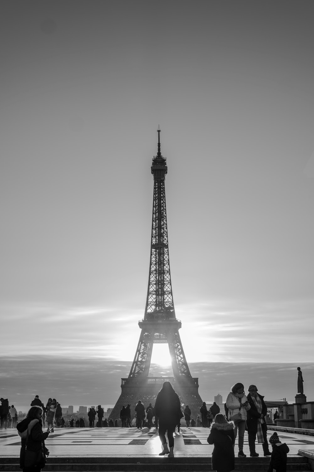 a group of people standing in front of the eiffel tower