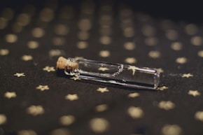 a small glass bottle with a cork sticking out of it