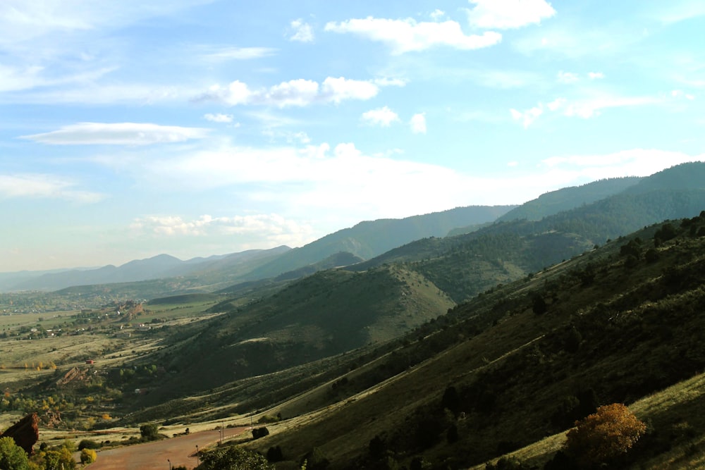 a scenic view of a valley with mountains in the background