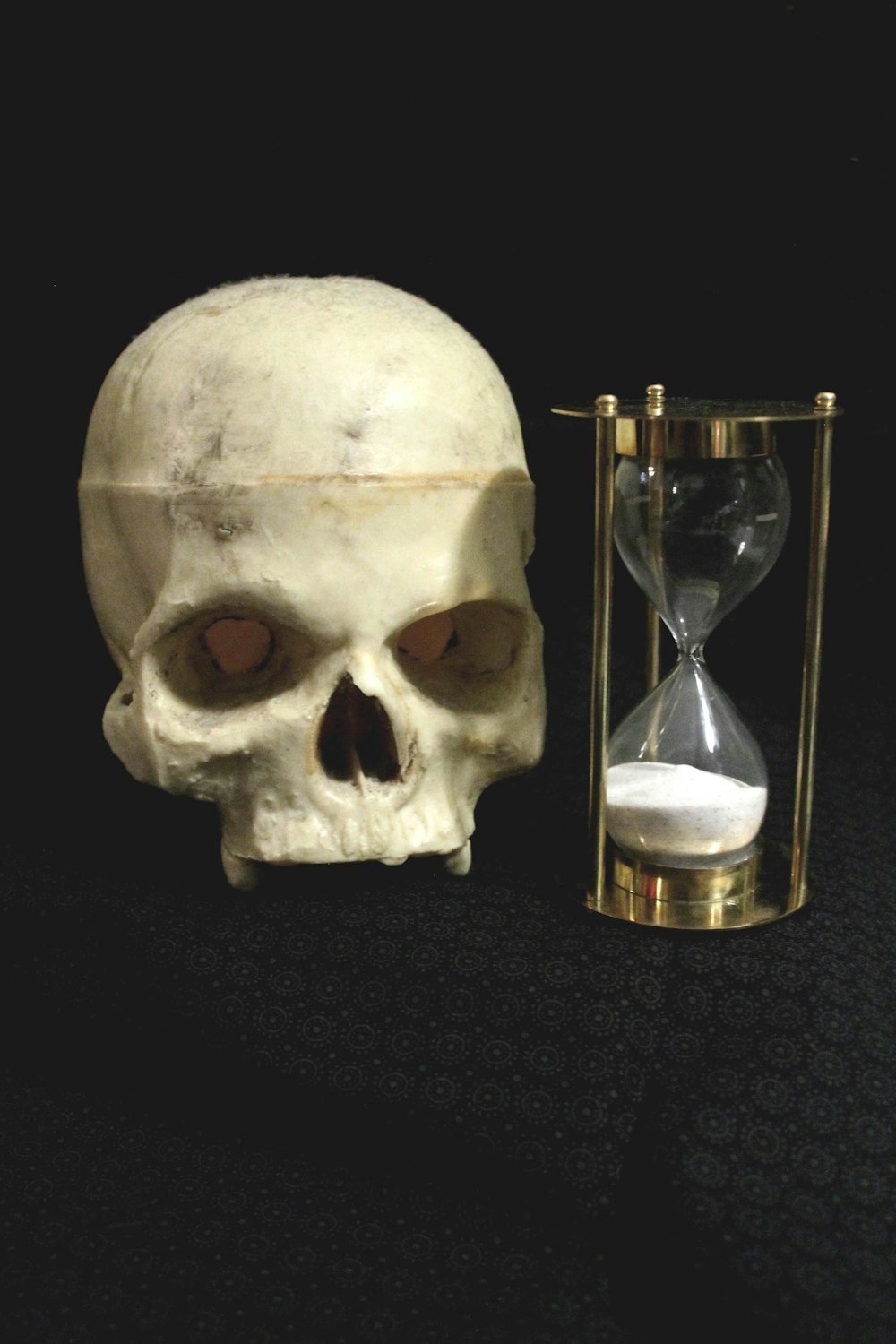 a human skull next to an hourglass
