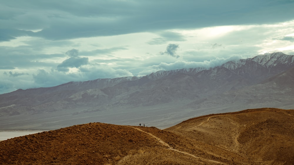 a couple of people standing on top of a hill