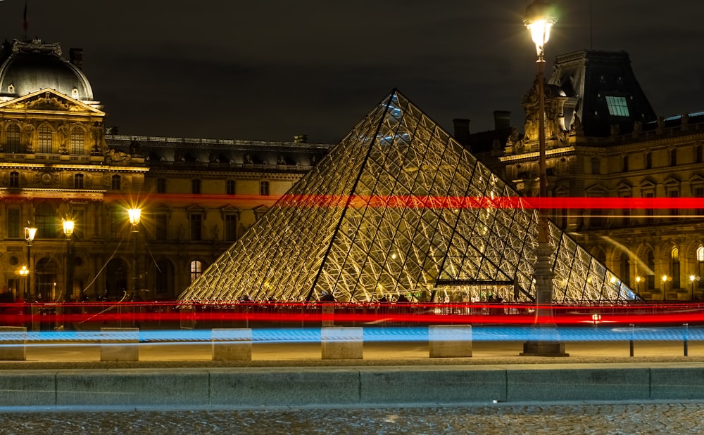 a long exposure photo of a building with a pyramid in front of it