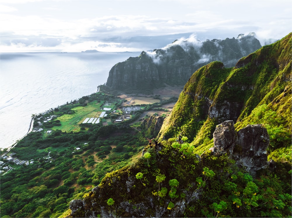 a scenic view of a mountain with a body of water in the background