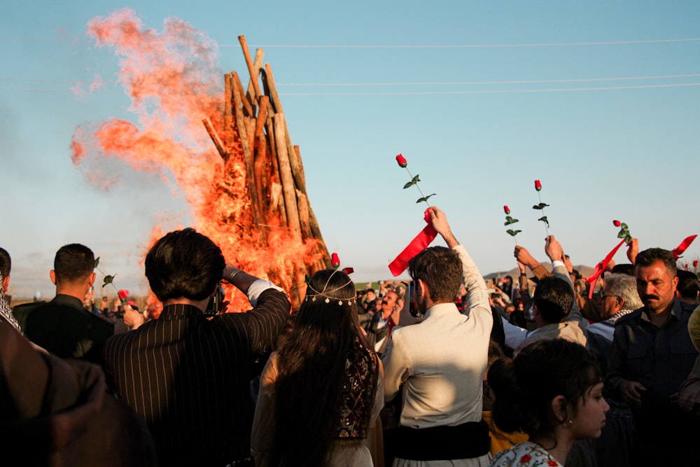 a large group of people standing around a fire