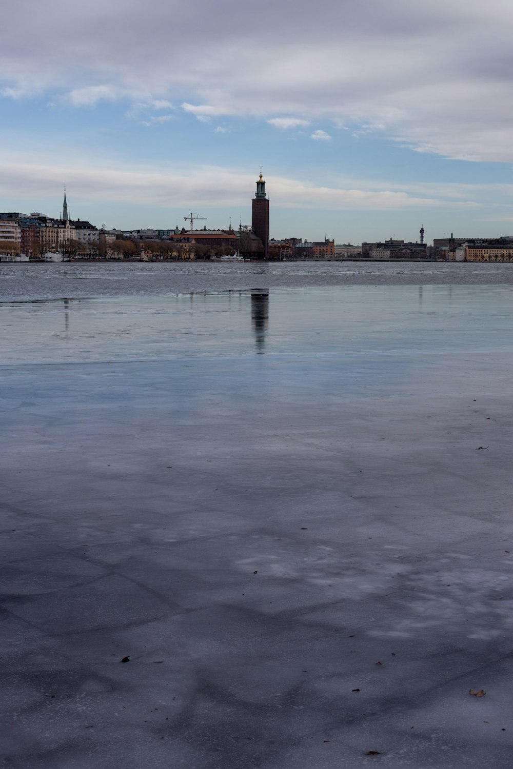 Un grande specchio d'acqua con una torre dell'orologio sullo sfondo