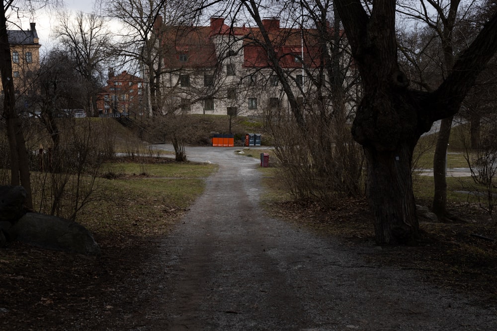 a dirt road in front of a large house