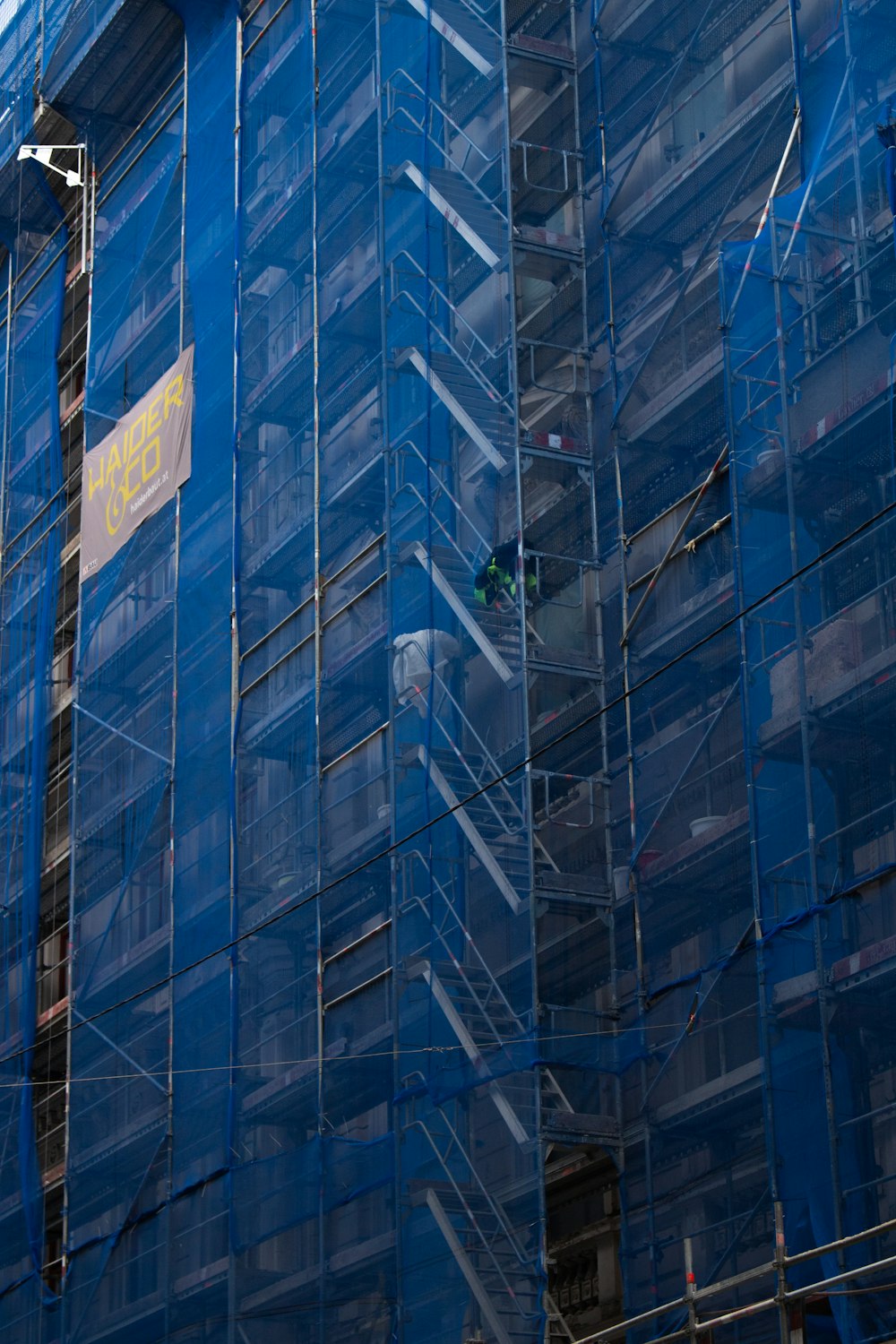 a large blue building with scaffolding around it