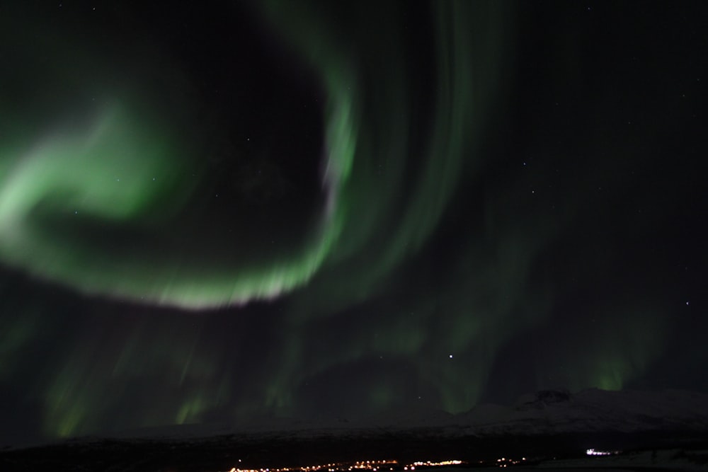 a green and white aurora bore in the night sky
