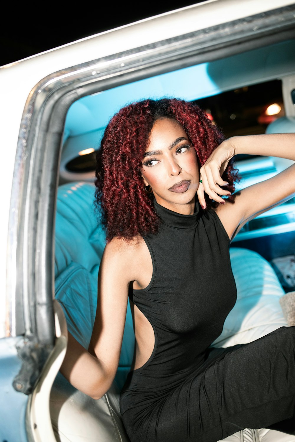 a woman with red hair sitting in a car