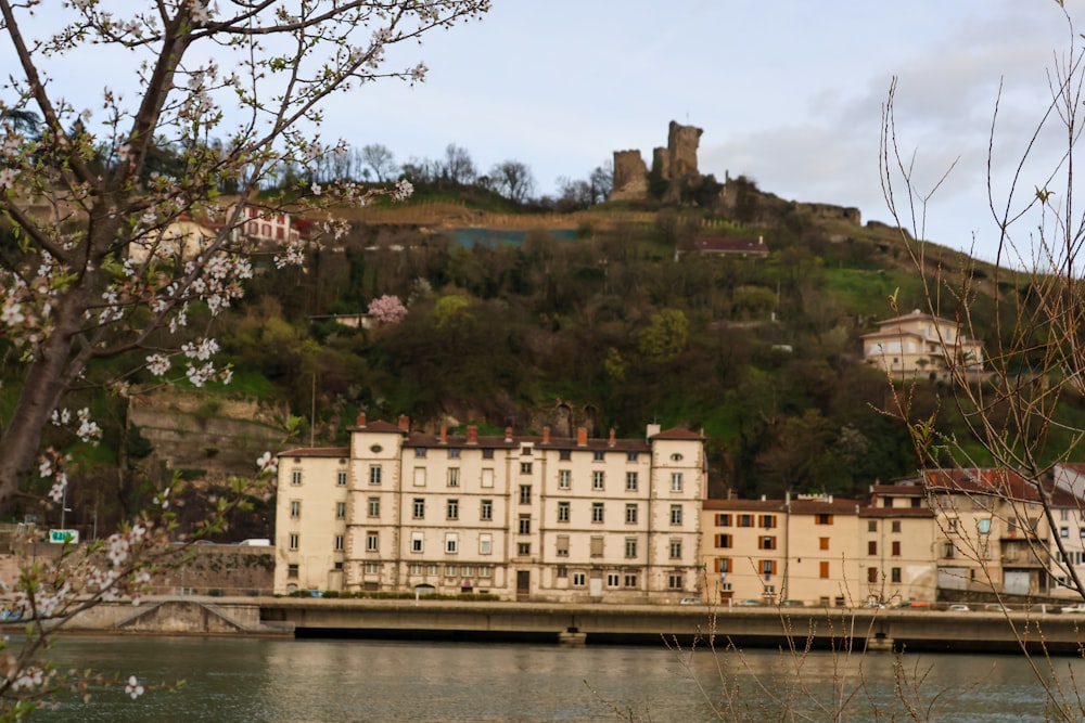 a large building sitting on top of a hill next to a river