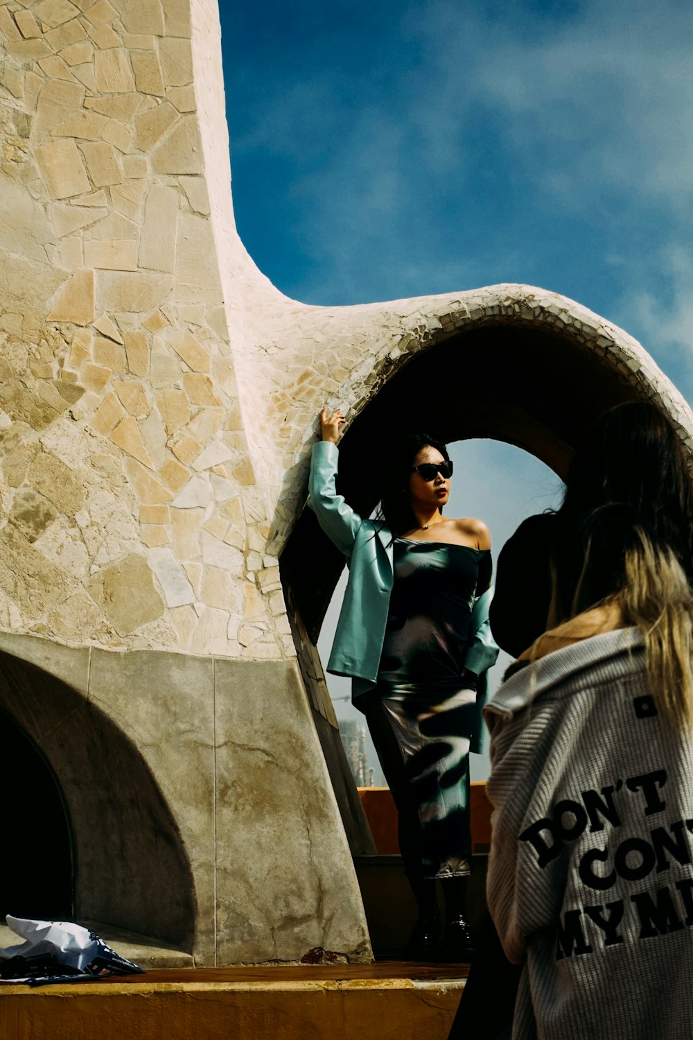 a woman standing in front of a stone structure