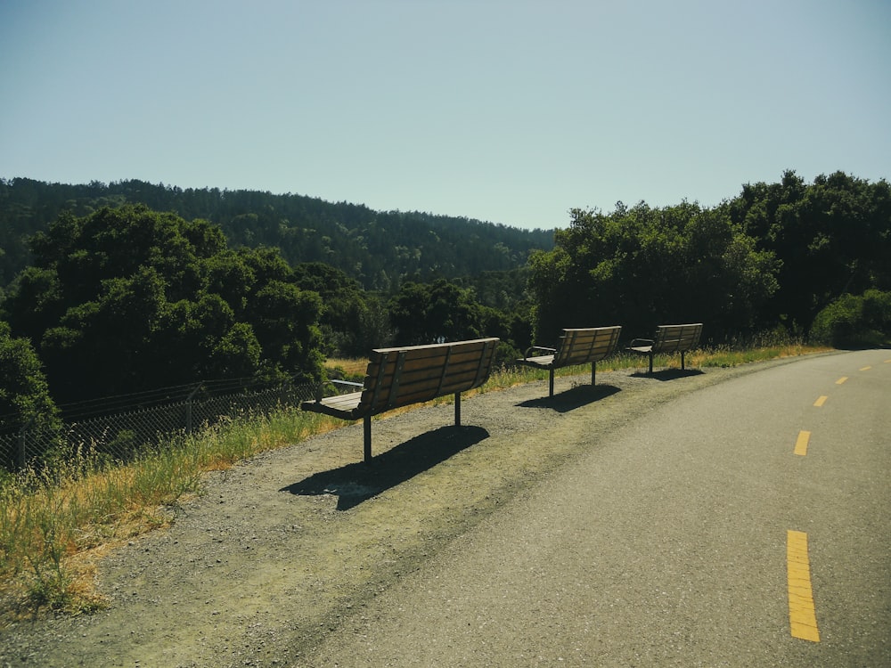 a couple of benches sitting on the side of a road