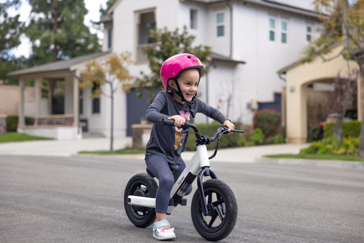 a little girl riding a small bike on the street