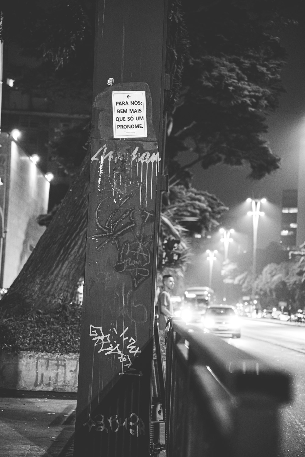 a black and white photo of graffiti on a pole