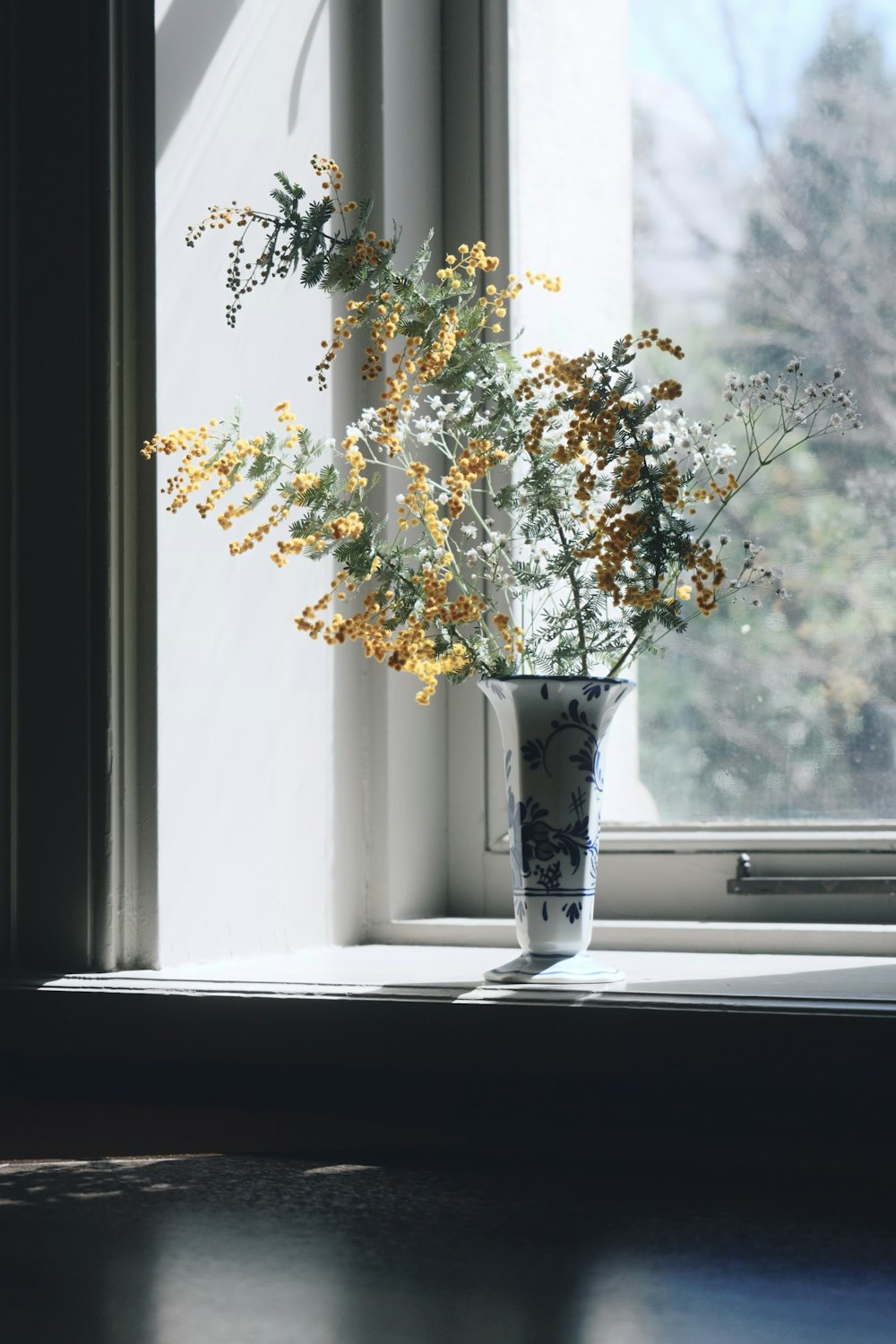 a vase of flowers sitting on a window sill