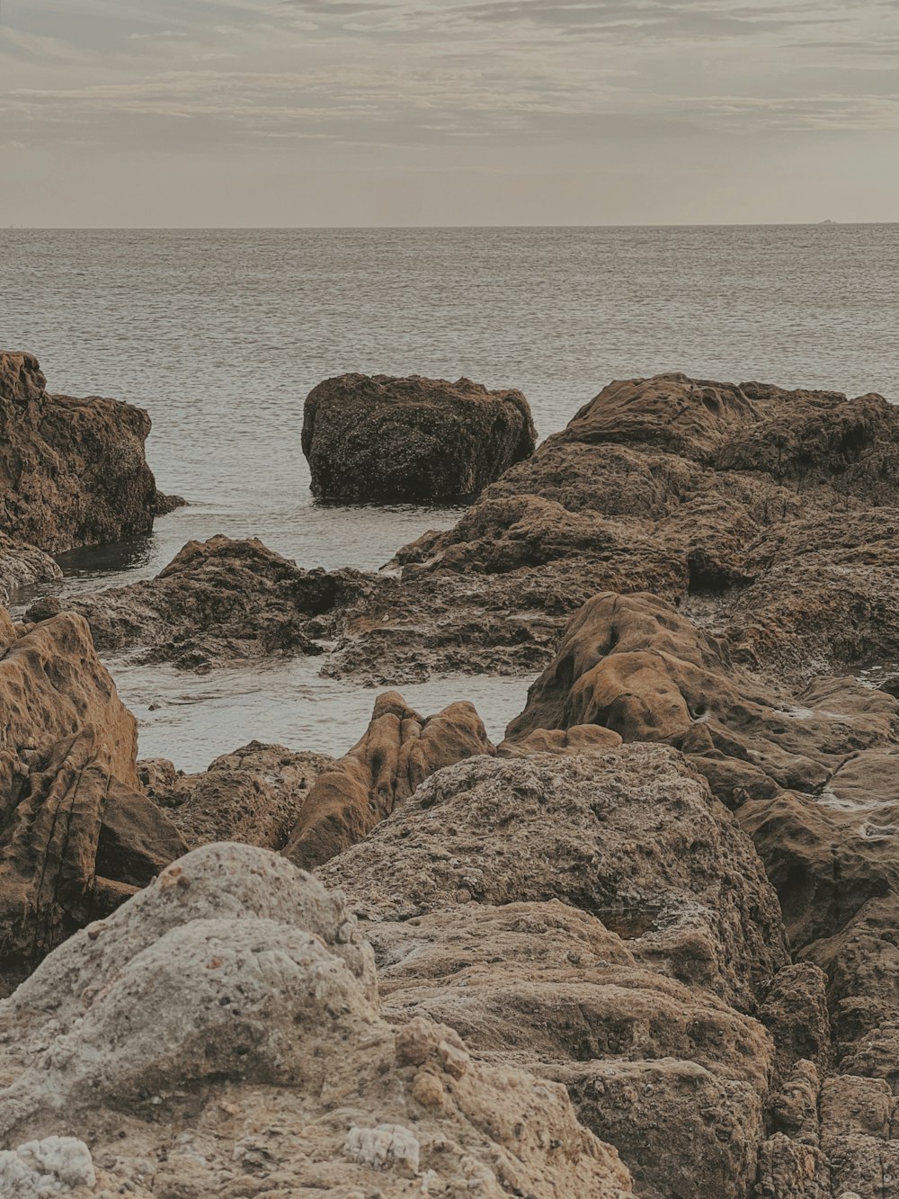 a couple of rocks sitting on top of a beach