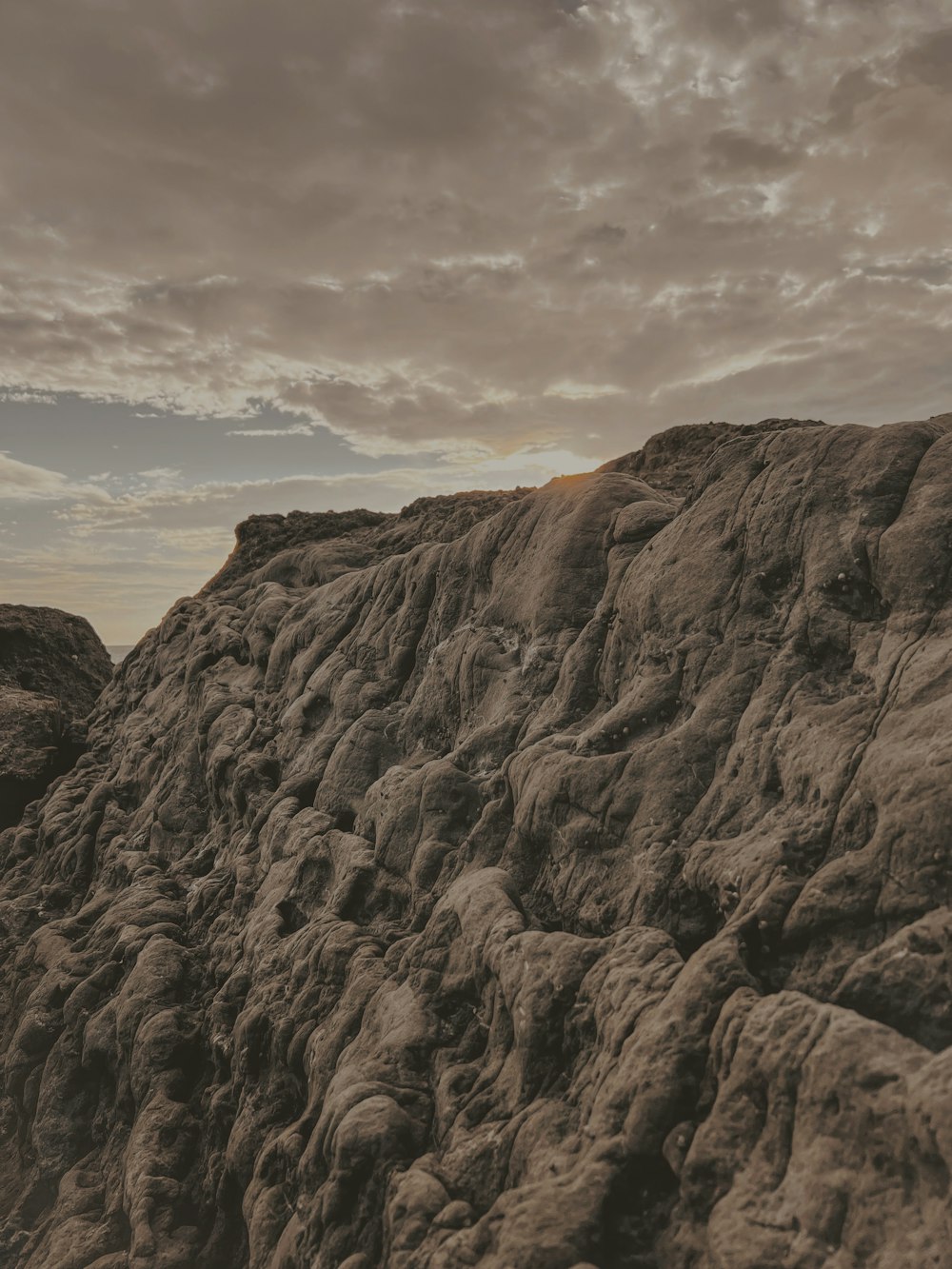 a man riding a surfboard on top of a large rock