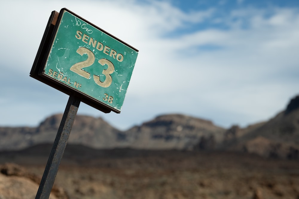 a street sign in front of a mountain range