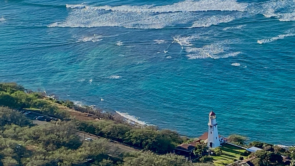 an aerial view of a lighthouse and the ocean