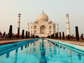 a large white building with a pool in front of it