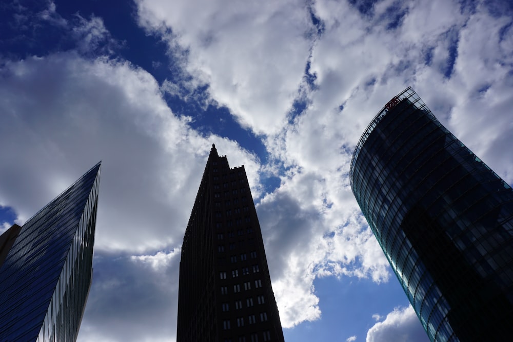 a group of tall buildings under a cloudy blue sky