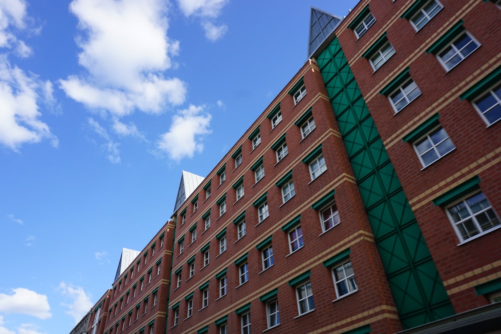 a red brick building with green shutters and windows