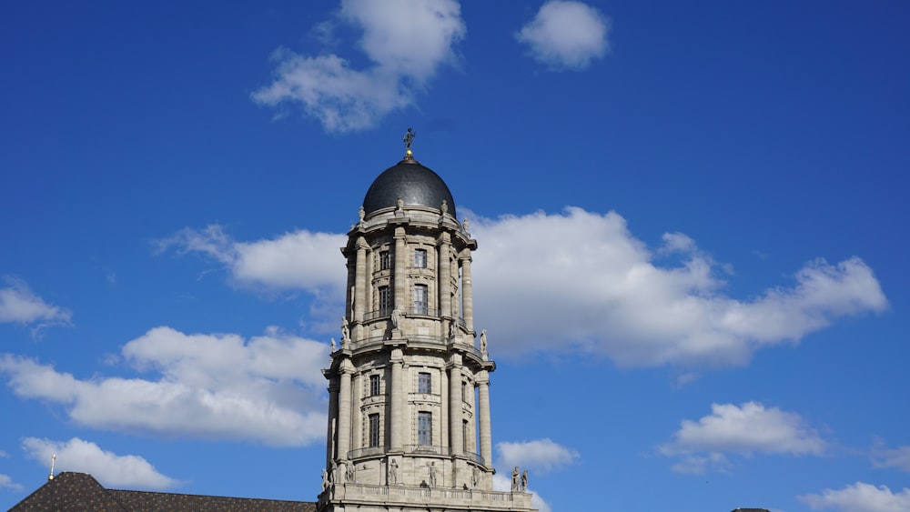 a clock tower on top of a building under a cloudy blue sky