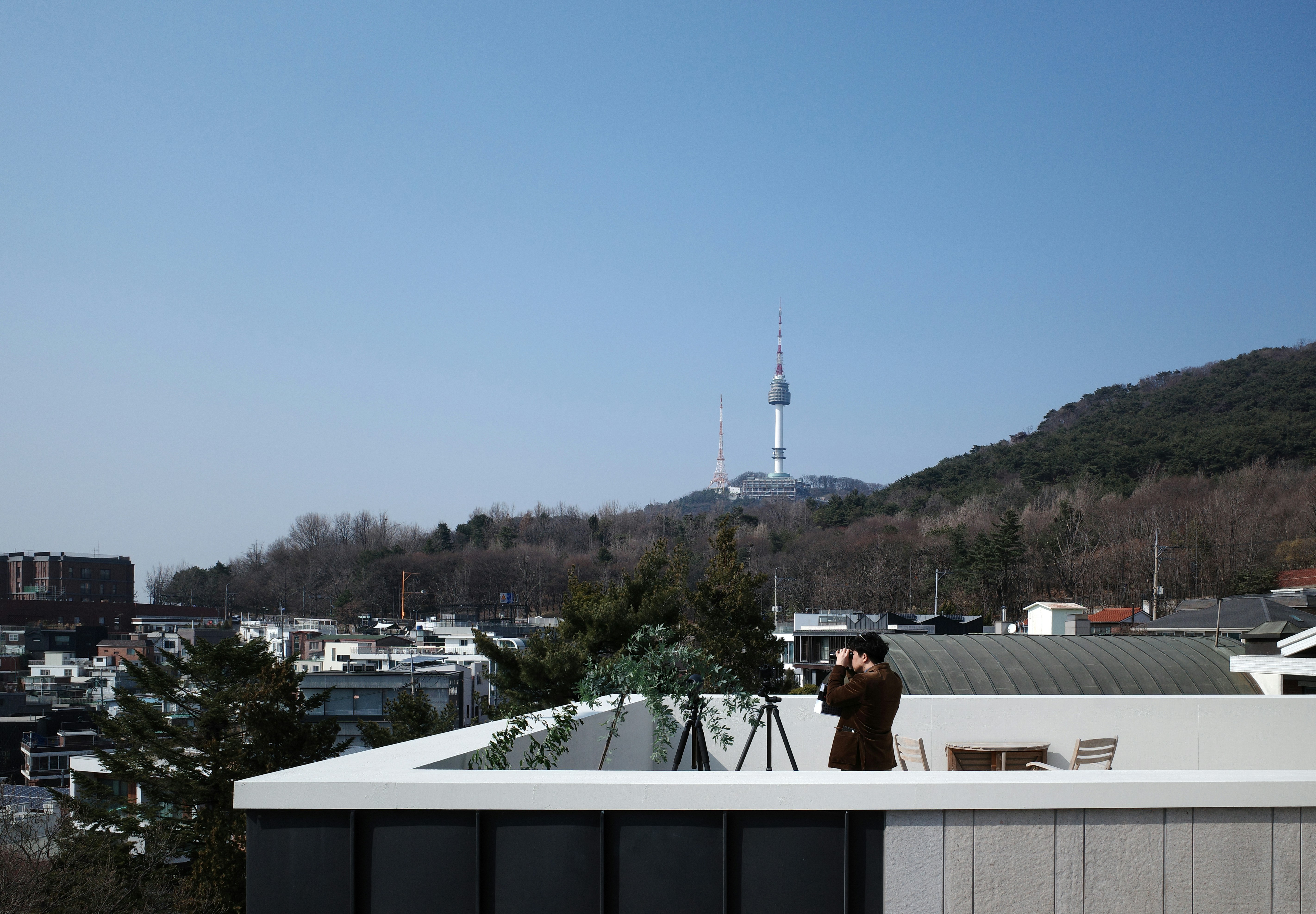 a person taking a picture of a city from a roof