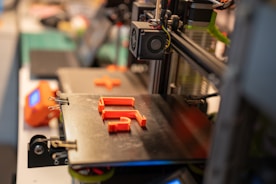 a close up of a machine with orange pieces on it