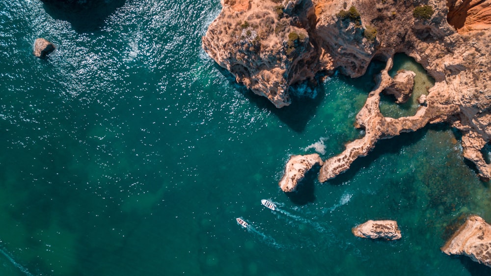 an aerial view of a body of water surrounded by rocks