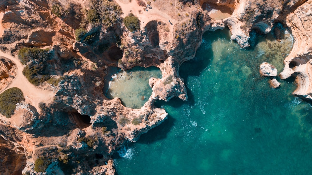 an aerial view of a body of water surrounded by rocks