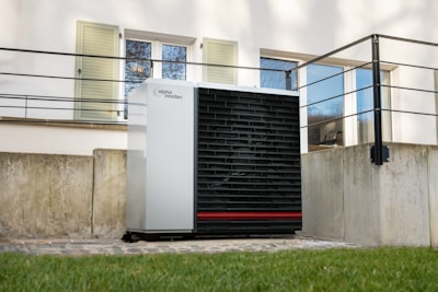 a white air conditioner sitting in front of a building