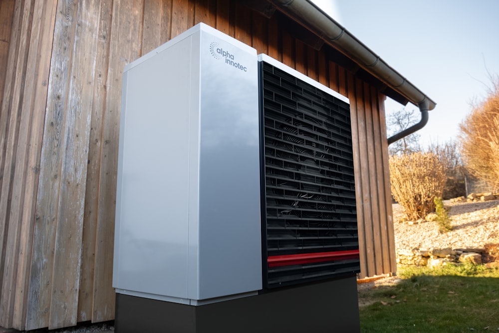 a white and black air conditioner sitting outside of a building