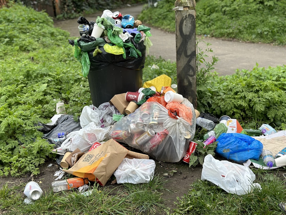 a pile of garbage sitting next to a trash can