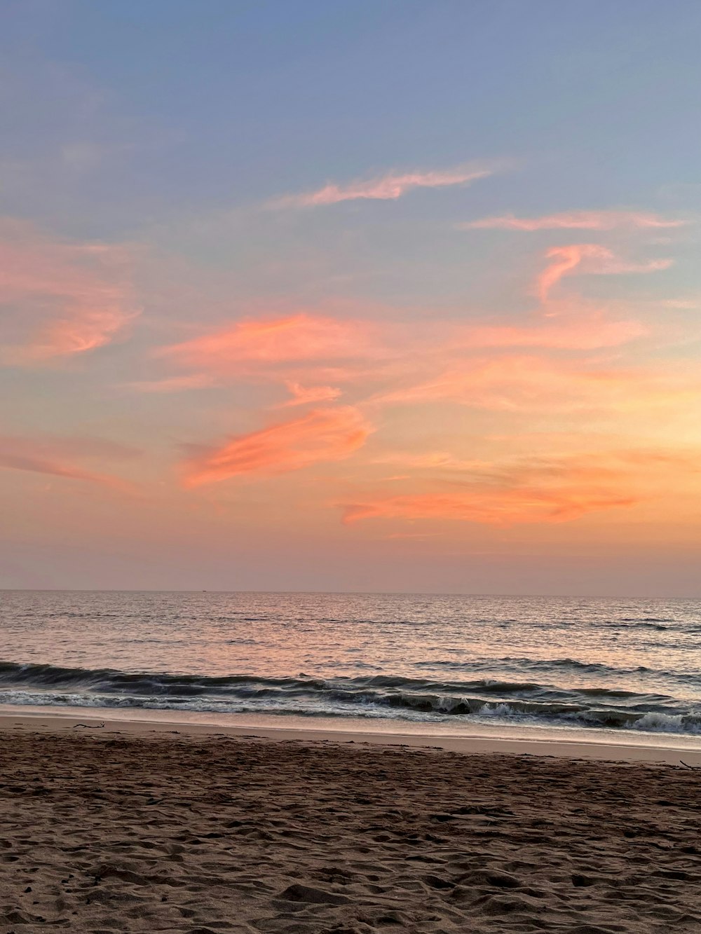 a person walking on a beach with a surfboard