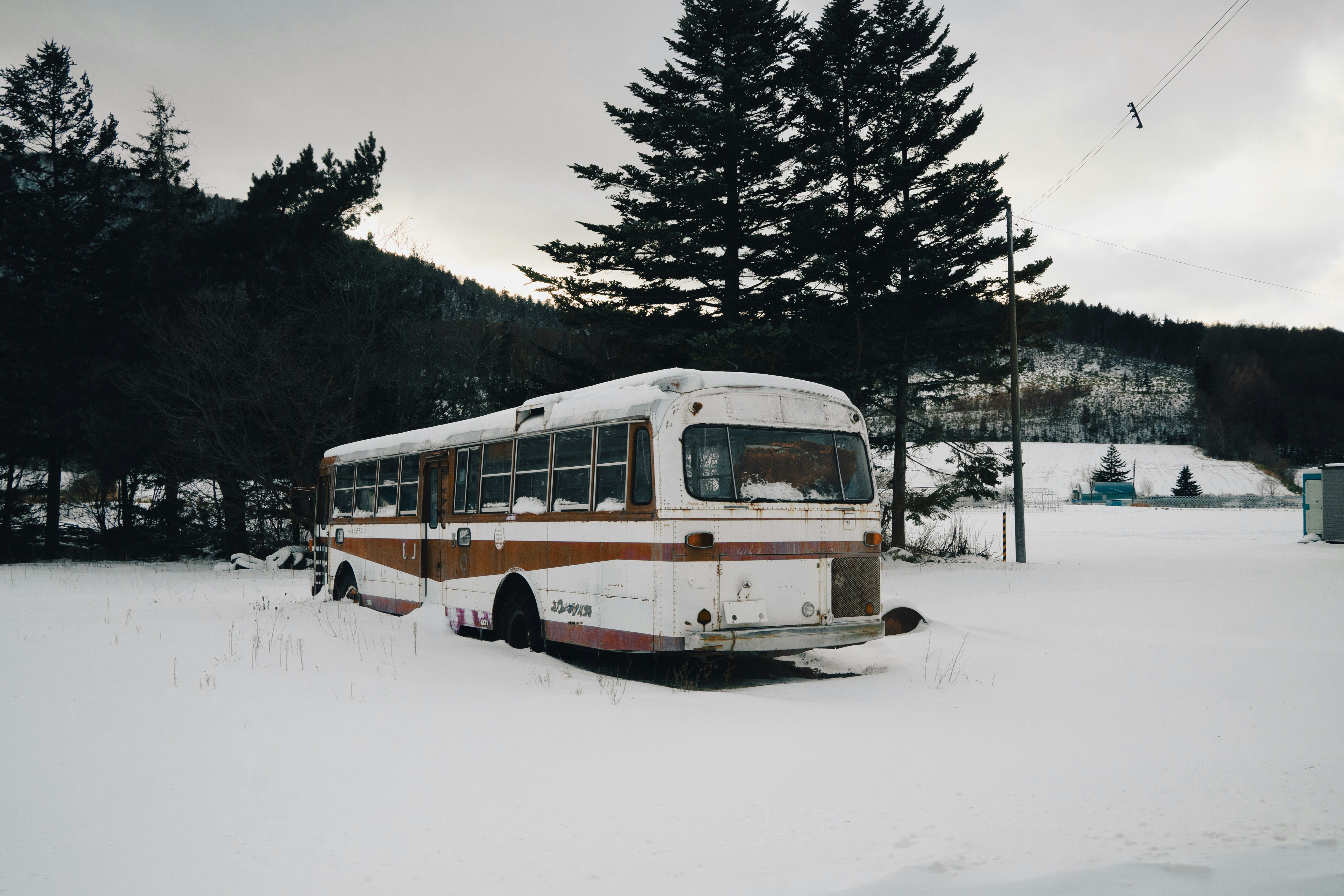 an old bus is parked in the snow